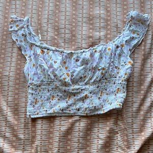 White cropped tank top with puffy sleeves. Multicolored flowers. Ribbed waist